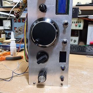 The aluminium front plate standing upright with the LCD, knobs and tuning knob fitted