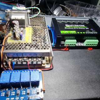 The power supply, the Modbus relay board and a four-relay module laid out on the bench